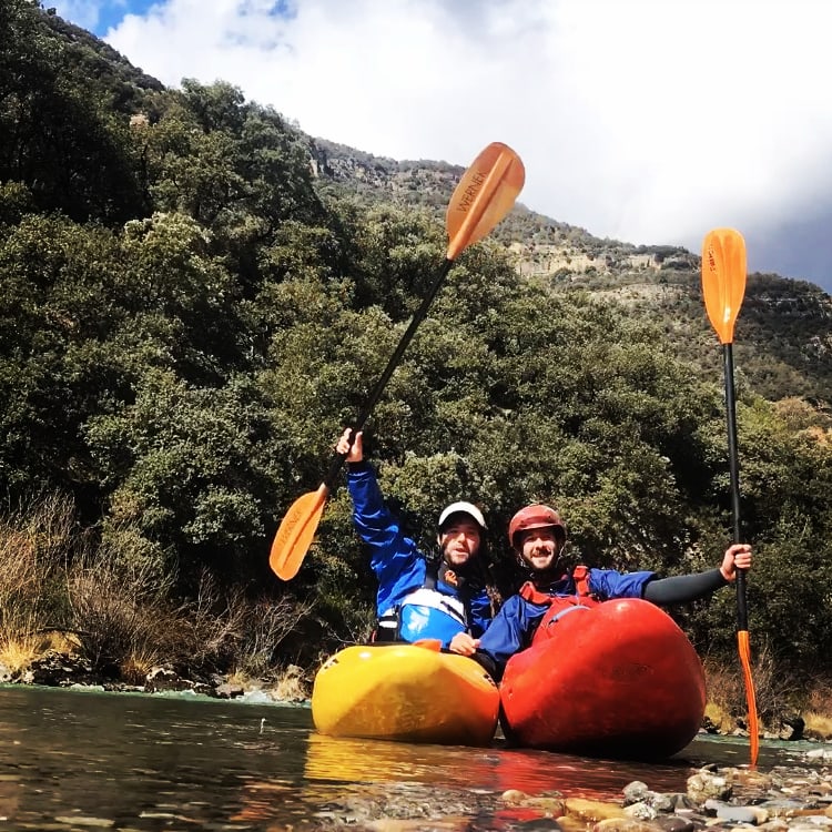 Imagen de una pareja practicando piragüismo saludando con sus remos. Deportes de aventura Huesca